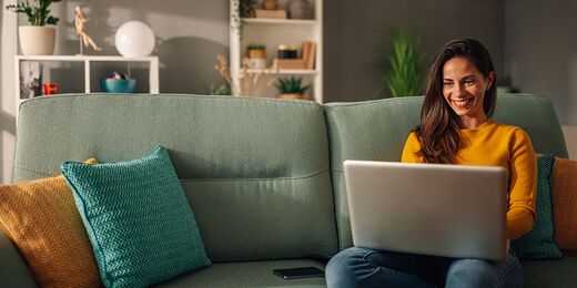 Surreales Bild einer schwebenden Frau vor einem Bildschirm in einem Wohnzimmer