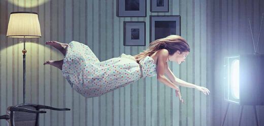 Surreales Bild einer schwebenden Frau vor einem Bildschirm in einem Wohnzimmer